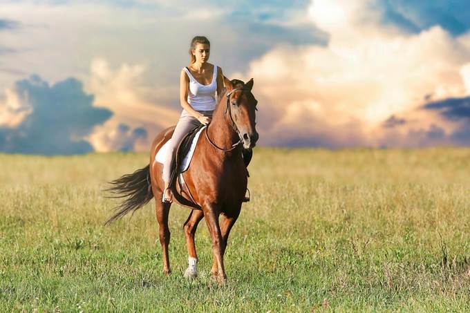 A woman riding a horse confidently.